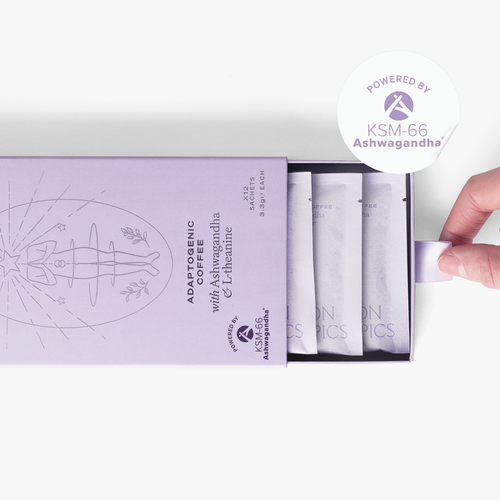 Slightly opened box of Zen Ashwagandha and L-theanine adaptogenic coffee showing three single serve sachets. A hand pull the box open. In the top right corner is a sticker that reads: Powered by KSM-66 Ashwagandha.