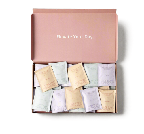 London Nootropics pink mixed coffee box that reads "elevate your day" on the inner lid, open and full of mixed coffee