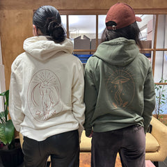 Two women in London Nootropics hoodies in white Find Your Flow (L) and khaki Mushroom Rising (R)