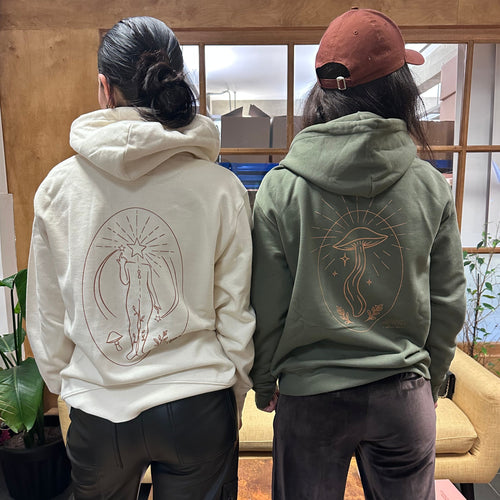 Two women in London Nootropics hoodies in white Find Your Flow (L) and khaki Mushroom Rising (R)