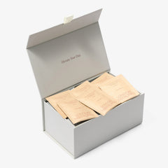 Open grey box of London Nootropics coffee, positioned at an angle on a white backdrop. The box displays six sachets of flow adaptogenic coffee blend which features Lion's Mane and Rhodiola.